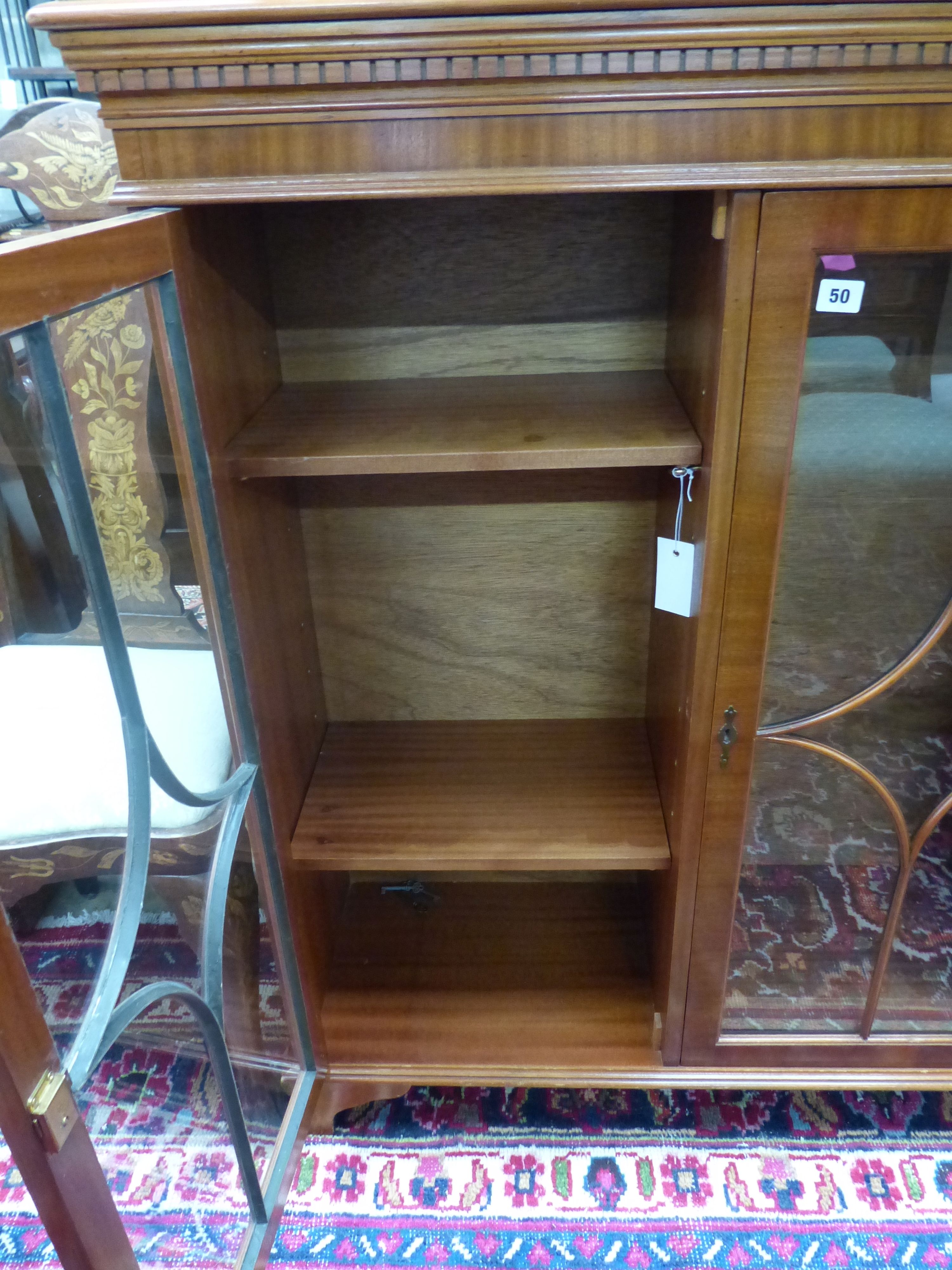 A reproduction mahogany three door bookcase, width 135cm depth 33cm height 116cm